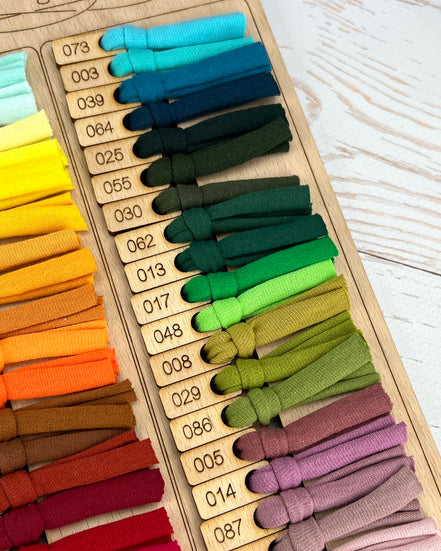 Color swatch chart with various colored bands on a wooden board