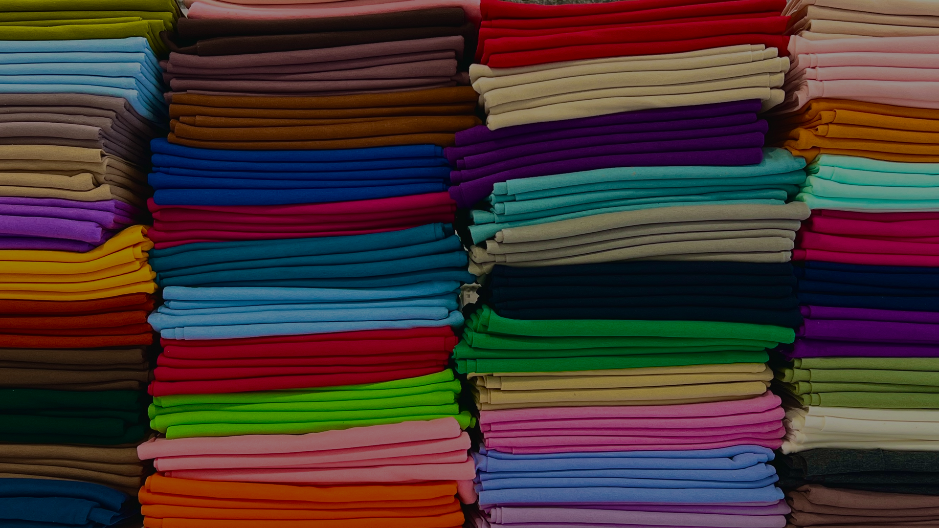Stacks of colorful fabric in various patterns and colors.